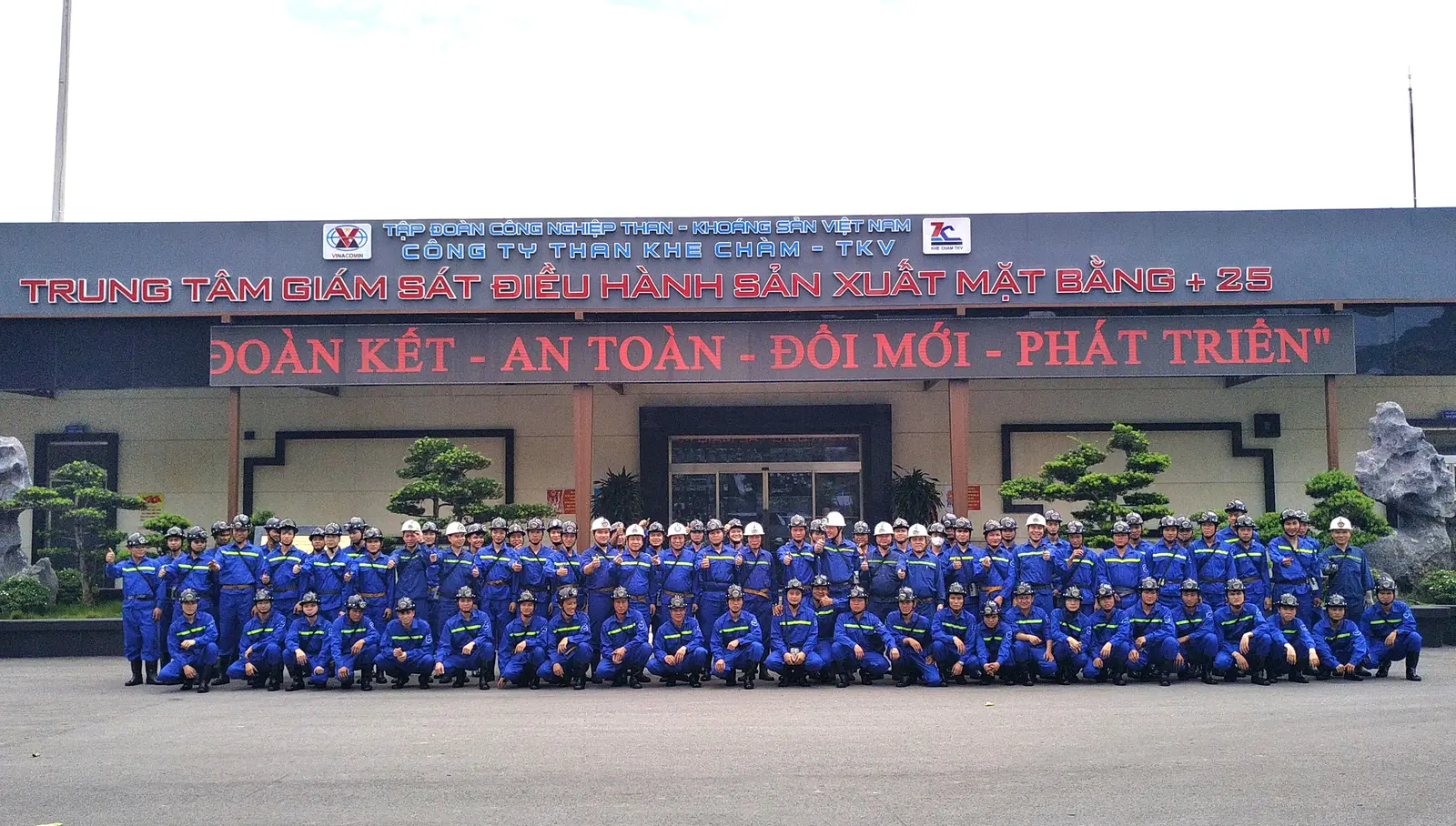 Nhóm học sinh nghề mỏ mặc bảo hộ xanh và đội mũ trong chuyến tham quan thực tế tại Than Khe Chàm