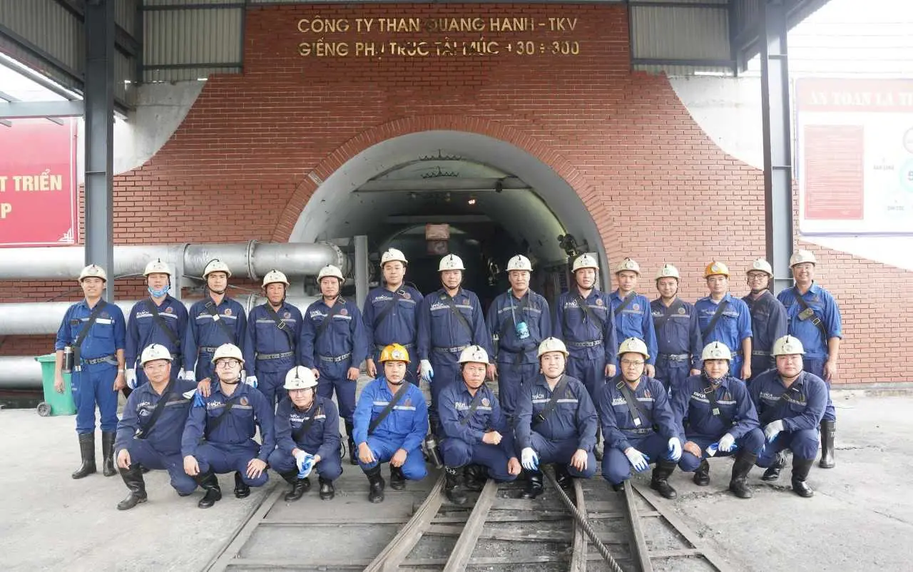 Nhóm học viên nghề mỏ mặc bảo hộ xanh, đội mũ tại khu thực hành Than Quang Hanh