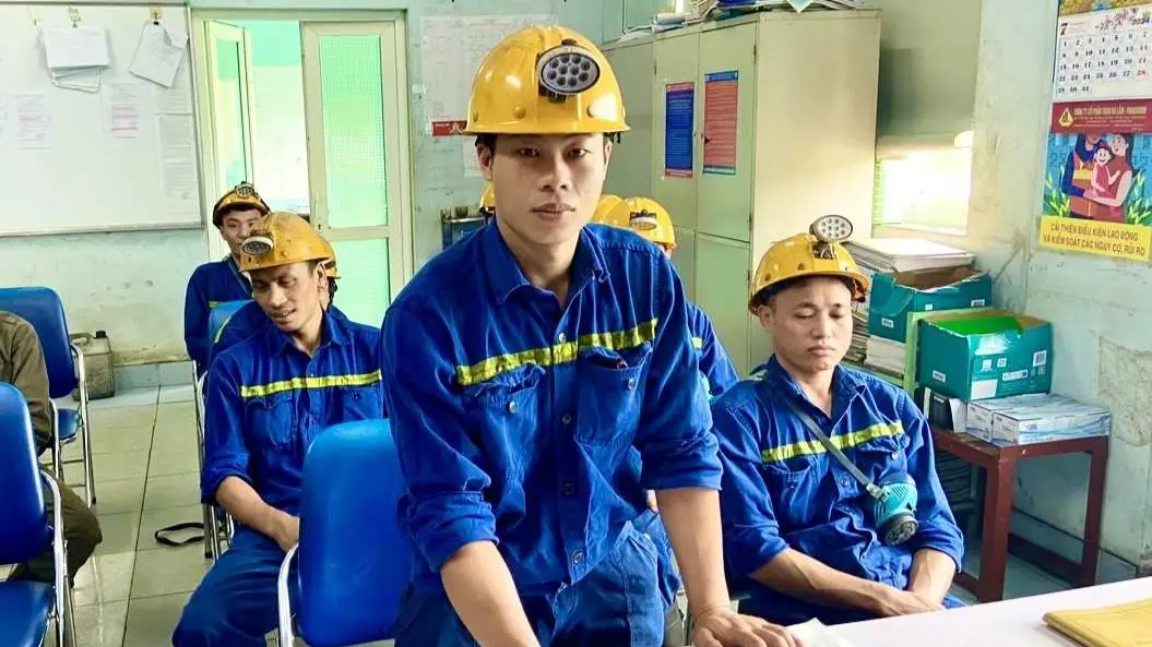 Nhóm thợ lò Than Hà Lầm mặc bảo hộ xanh, đội mũ trong buổi giao ca