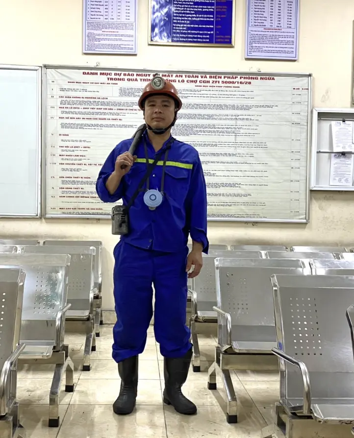 Công nhân thợ lò Khe Chàm mặc bảo hộ xanh, đội mũ và đèn lò tại khu giao ca